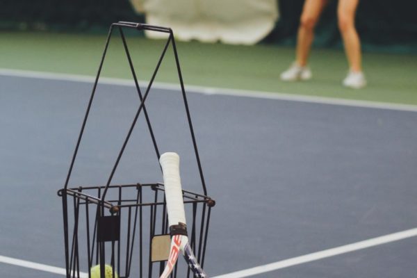 woman standing and holding tennis racket at the tennis court