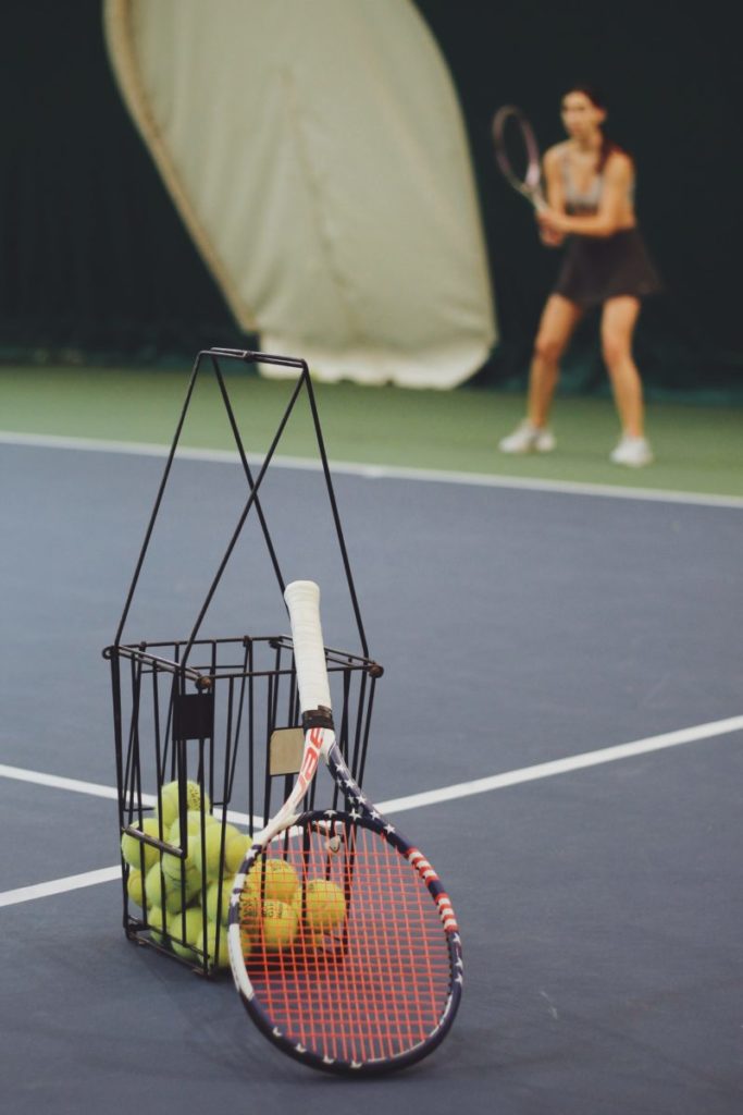 woman standing and holding tennis racket at the tennis court